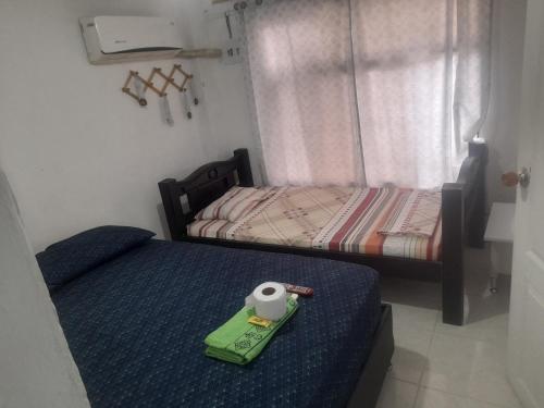 um quarto com 2 camas e uma bandeja verde numa cama em Hotel & Restaurante Doña Nerta bosque em Cartagena das Índias