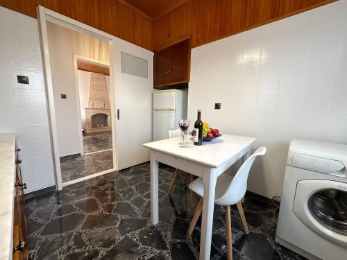 a kitchen with a white table and a sink at Magdalini House in Paralion astros