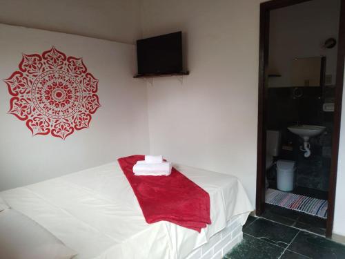 Un dormitorio con una cama con una toalla roja. en Pousada Quintão en Santana do Riacho