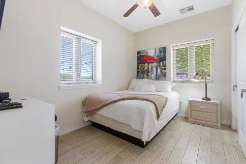 1 dormitorio blanco con 1 cama y 2 ventanas en Contemporary 1BR Loft Downtown Branson - FREE TICKETS INCLUDED, en Branson