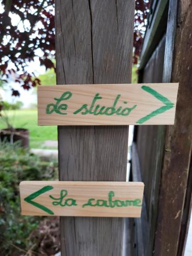 two wooden signs on a wooden pole with the words be birds do explore at A la salle de jeux in Dinant