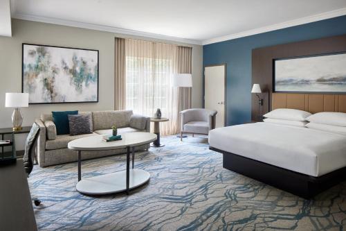 Westfields Marriott Washington Dulles في شانتيلي: غرفه فندقيه بسرير واريكه