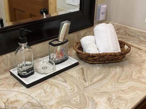 a bathroom counter with a basket of towels and a mirror at Cozy cabin with boosted Wi-Fi in Beech Mountain