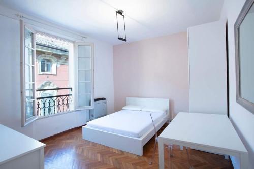 a white room with two beds and a window at Palazzo del Giglio in Reggio Emilia