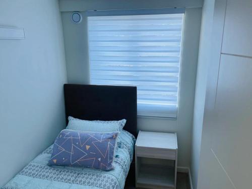 um pequeno quarto com uma cama e uma janela em RUCAMAR em Osorno