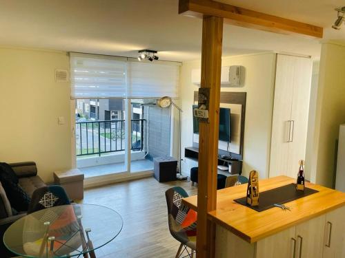 RUCAMAR في أوسورنو: مطبخ وغرفة معيشة مع طاولة زجاجية