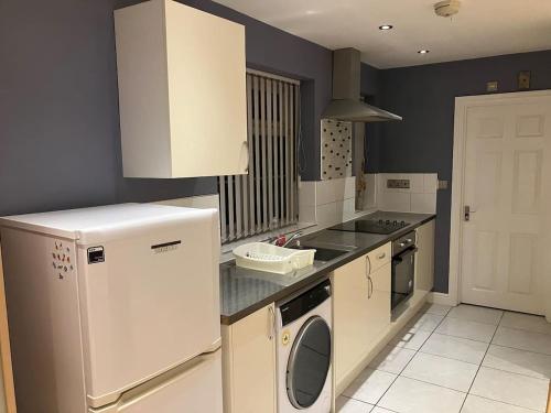 uma cozinha com um frigorífico branco e uma máquina de lavar louça em Work-Play Stylish, Speedwell Apartment, Free Parking em Bristol