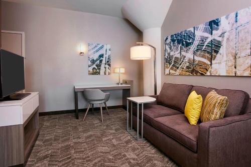 a living room with a couch and a desk at SpringHill Suites by Marriott Milwaukee Downtown in Milwaukee