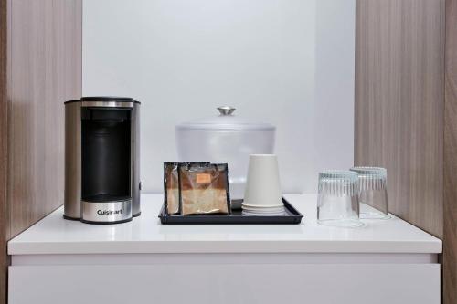 a counter with a coffee maker and glasses on it at SpringHill Suites by Marriott Milwaukee Downtown in Milwaukee
