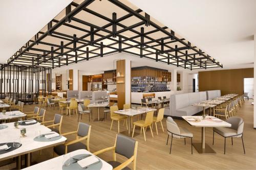a rendering of a restaurant with tables and chairs at Courtyard by Marriott Sejong in Sejong