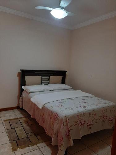 a bedroom with a bed with a white blanket on it at Apartamento Confortável in Marechal Floriano