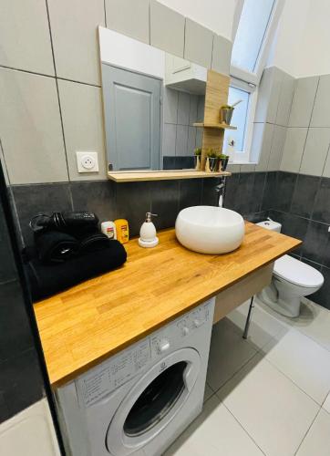 une salle de bain avec une machine à laver et un lavabo dans l'établissement jolie maison individuelle 50 m2 ,design et climatisée, tout confort, wifi, terasse privée , 5 min plage et autoroute, stationnement gratuit, à Marseille