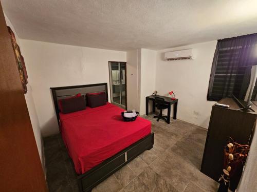 1 dormitorio con cama roja y escritorio en Whole House by Beach - Relaxing & Family Friendly!, 