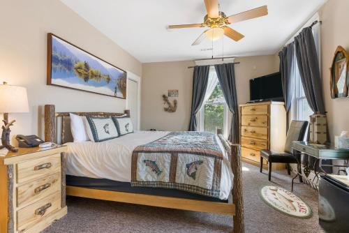 a bedroom with a bed and a dresser and a television at Historic Branson Hotel - Fisherman's Cove Room with King Bed - Downtown - FREE TICKETS INCLUDED in Branson