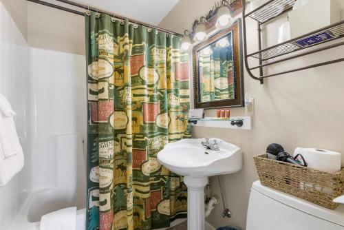 baño con lavabo y cortina de ducha en Historic Branson Hotel - Fisherman's Cove Room with King Bed - Downtown - FREE TICKETS INCLUDED, en Branson