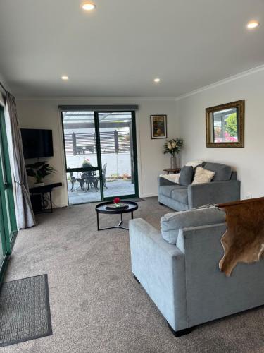 a living room with two couches and a table at Boutique on Edinburgh in Invercargill