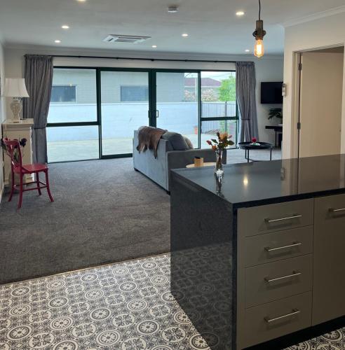 a kitchen and living room with a couch and a table at Boutique on Edinburgh in Invercargill