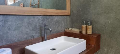 bagno con lavandino bianco e specchio di Rua Beach Resort Sumba a Rua