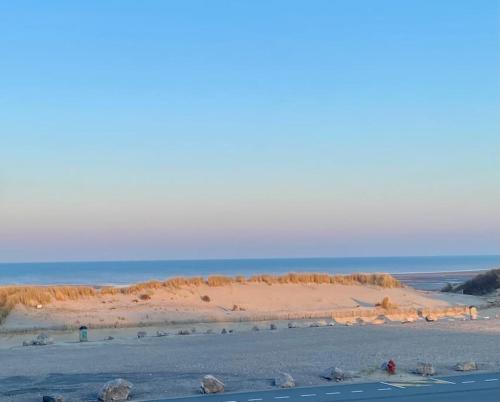 Une plage de sable et l'océan en arrière-plan dans l'établissement Studio Entre MER ET DUNES avec balcon vue laterale MER 50m plage pour 3 pers wifi ménage compris, à Fort-Mahon-Plage