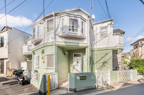 a green and white house on a street at BISK PARK TOKYO - 4LDK&2Bath Spacious House - Easy Access to Asakusa, Skytree & Airport in Tokyo