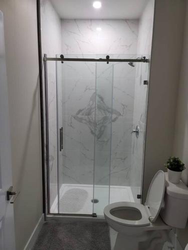 a bathroom with a glass shower with a toilet at Docker in Timberlea
