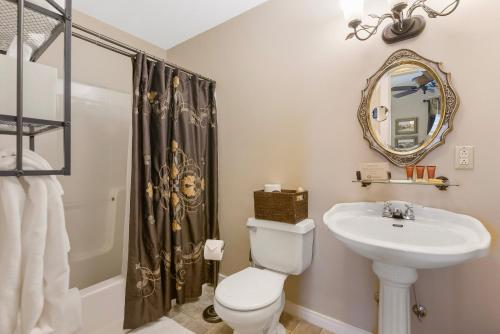 a bathroom with a toilet and a sink and a mirror at Historic Branson Hotel - Heritage Room with Queen Bed - Downtown - FREE TICKETS INCLUDED in Branson