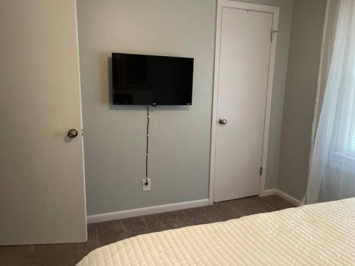 a bedroom with a flat screen tv on a wall at Beautiful 3-bedroom home next to Ft Bragg in Fayetteville