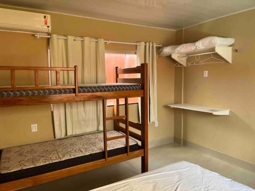 a room with three bunk beds and a bed at Casa de férias ventilada com 4 quartos à 5 min da praia in Salinópolis