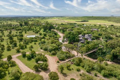 an aerial view of a field with trees and houses at JW Marriott Masai Mara Lodge in Masai Mara