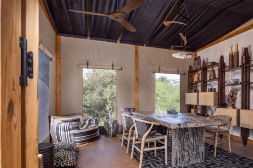 a dining room with a table and chairs at JW Marriott Masai Mara Lodge in Masai Mara