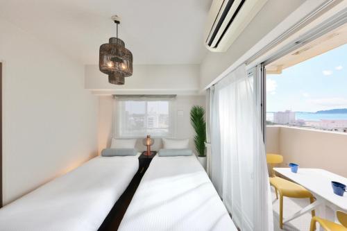 a bedroom with a large bed and a window at City Life Miyako L'avenir in Miyako-jima
