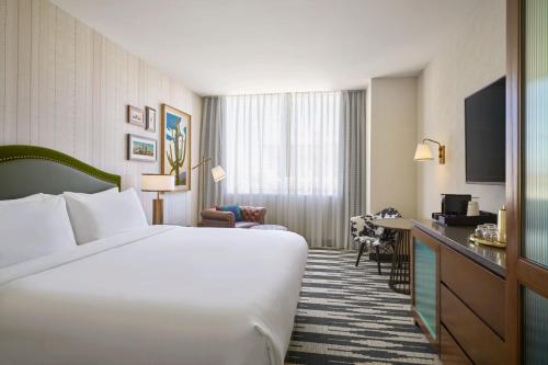 a hotel room with a large bed and a television at The Leo Kent Hotel, Tucson, a Tribute Portfolio Hotel in Tucson