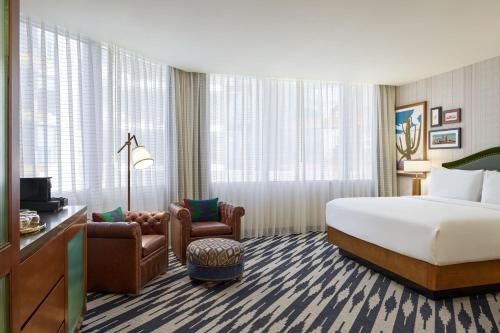 ツーソンにあるThe Leo Kent Hotel, Tucson, a Tribute Portfolio Hotelのベッドと椅子付きのホテルルーム