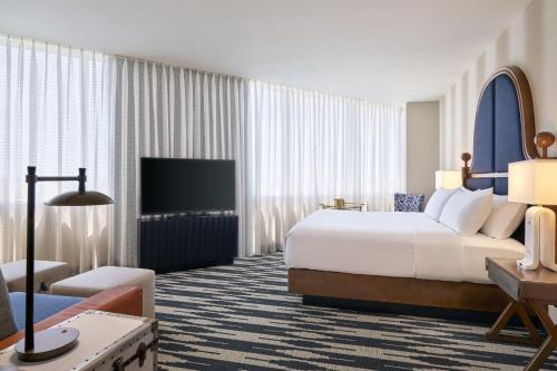 a hotel room with a bed and a television at The Leo Kent Hotel, Tucson, a Tribute Portfolio Hotel in Tucson