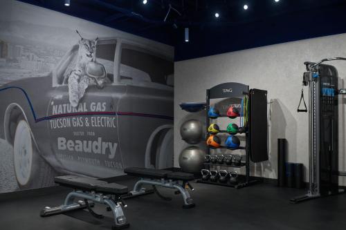a room with a wall with a car and a fitness room with a barber at The Leo Kent Hotel, Tucson, a Tribute Portfolio Hotel in Tucson
