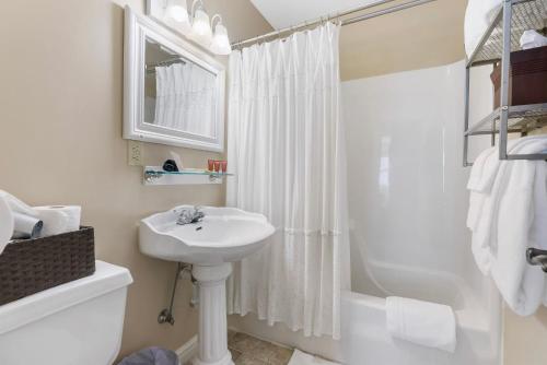 a white bathroom with a sink and a shower at Historic Branson Hotel - Quiet Quilt Room with King Bed - Downtown - FREE TICKETS INCLUDED in Branson