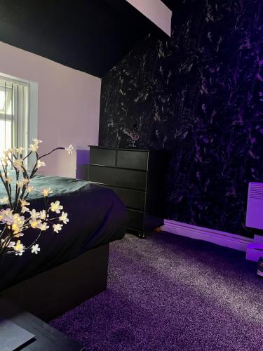 a bedroom with a bed and a purple wall at Private Penthouse Suite 