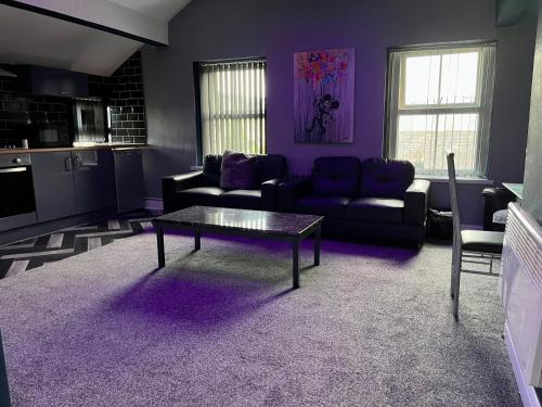 a living room with purple walls and a table at Private Penthouse Suite 