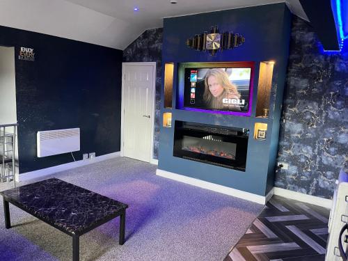 Habitación con chimenea y TV en la pared. en Private Penthouse Suite 