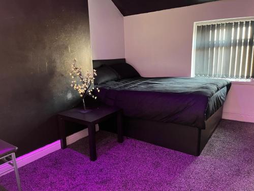 a bedroom with a bed and a purple carpet at Private Penthouse Suite 