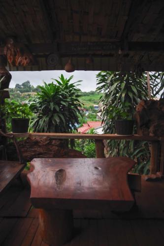 a wooden bench in a room with potted plants at FamilyHouse & Trekking in Banlung