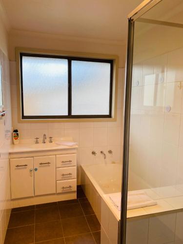 a bathroom with a tub and a sink and a shower at Intrigue FREE WI-FI in Apollo Bay