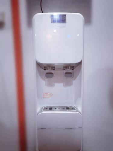 a white refrigerator with a water dispenser on top of it at Shangg INN in Ipoh