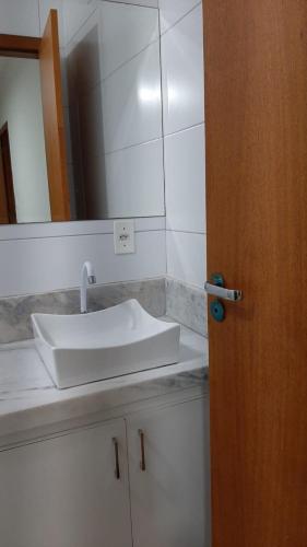 uma casa de banho com um lavatório branco e um espelho. em Jockey Family_Villaggio di Piazza em Vila Velha