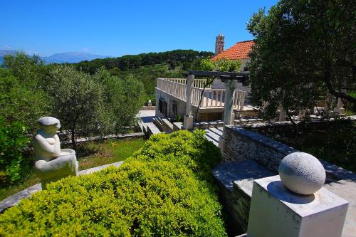 a statue of a woman sitting on a bench in a garden at Holiday Home Olea - Sun, Sea, Sport & Comfort in Splitska