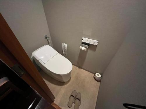 a bathroom with a toilet and a pair of slippers at Spa and Esthetique Suichokan-Female&Adult Only in Jozankei