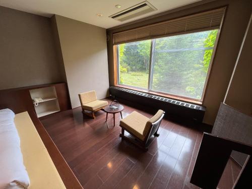a room with a bed and a large window at Spa and Esthetique Suichokan-Female&Adult Only in Jozankei