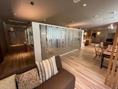 a living room with a couch and a dining room at Spa and Esthetique Suichokan-Female&Adult Only in Jozankei