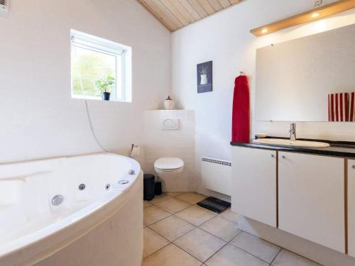 ein Badezimmer mit einer Badewanne, einem WC und einem Waschbecken in der Unterkunft Holiday home Esbjerg V X in Esbjerg