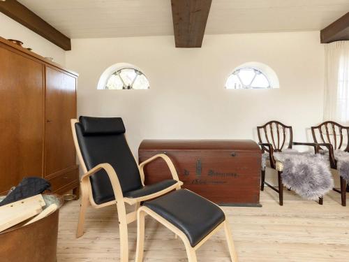 a room with chairs and a chest and windows at Holiday home Guldborg II in Guldborg